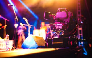 Professional video camera on stage filming live concert. Photo: iStock.com/mixetto