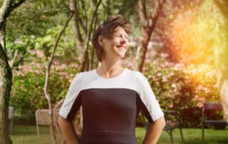 Exterior portrait of a smiling Carina Weijma in a luscious park setting.