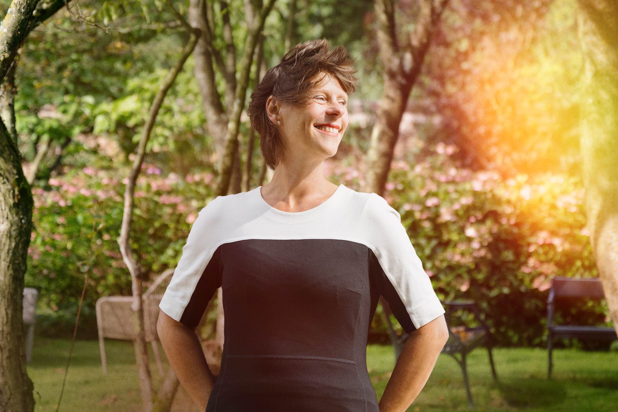 Exterior portrait of a smiling Carina Weijma in a luscious park setting.