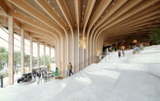 World of Volvo interior, showing circular stairs going up around the architectural wooden building core, with huge windows showing the surrounding nature.